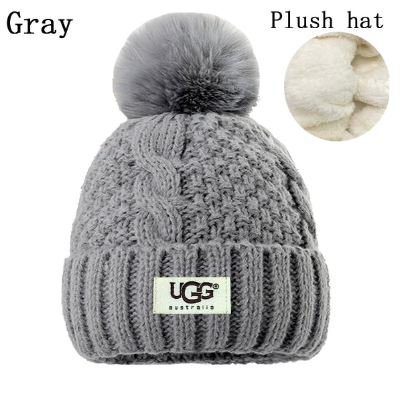 Gray knit beanie with pom-pom and UGG Australia logo on a white background
