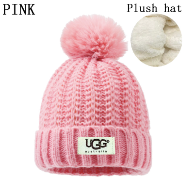 Pink knit beanie with pom-pom and UGG logo on a white background