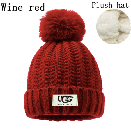 Red knit beanie with pom-pom and UGG label on a white background