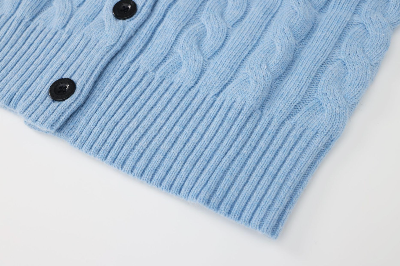 Light blue cable knit cardigan with black buttons on a white background