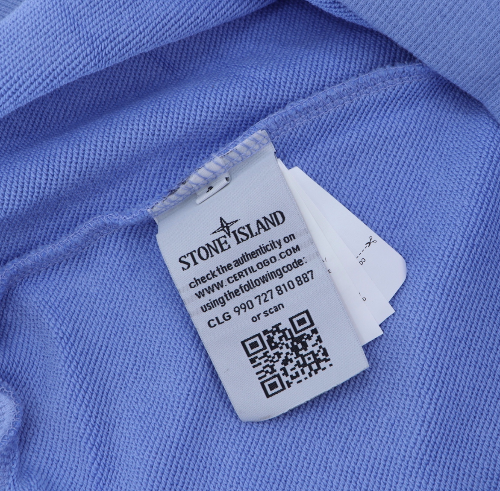Close-up of a Stone Island label on a blue fabric background