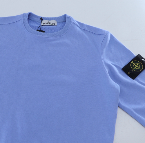 Light blue long-sleeve shirt with a brand tag on a light gray background