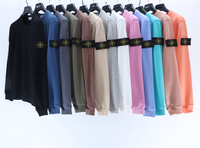 Row of colorful sweatshirts on hangers with a brand logo.