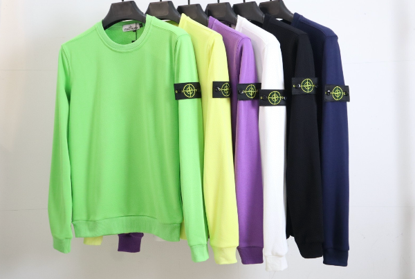 Five sweatshirts in green, yellow, purple, black, and white on hangers with a visible brand logo.