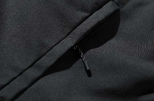 Close-up of a black zipper on a black fabric background