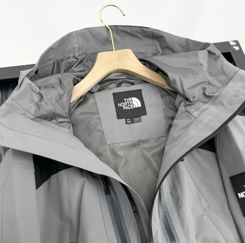 The North Face Hooded outdoor jacket in black and grey hanging on hangers