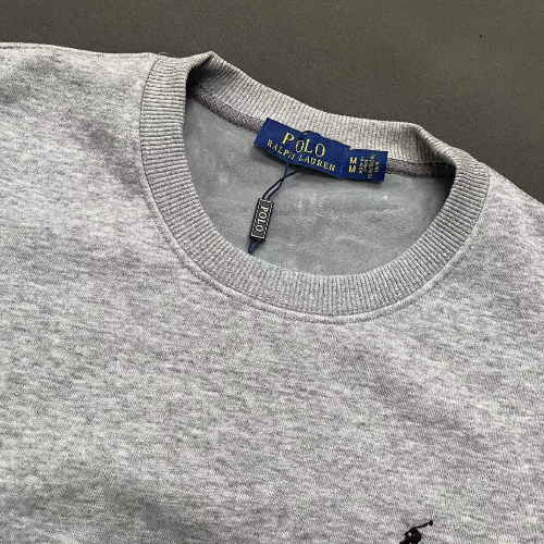 Gray sweater with Polo Ralph Lauren label on a dark background
