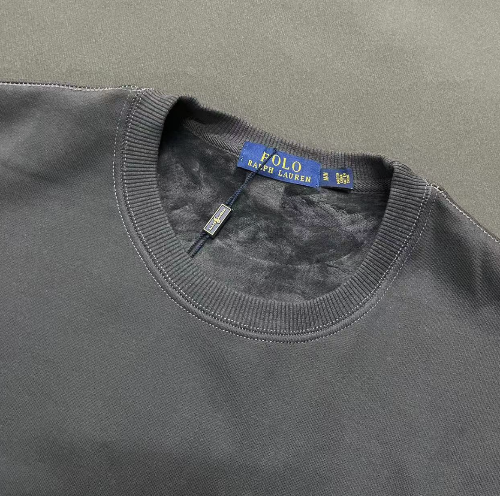 Close-up of a gray sweater with a Polo Ralph Lauren tag on a gray background