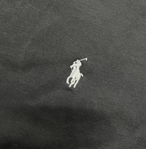White embroidered logo on a dark fabric background