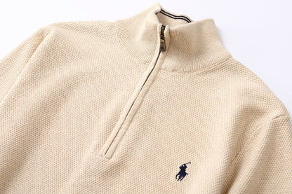 Close up of  Brown Zip cardigan with a black logo on a white background