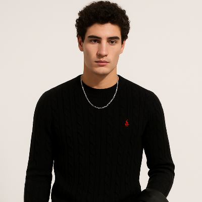 Man wearing a black sweater with a red logo on a beige background