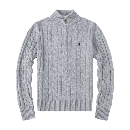 Grey blue cable knit sweater with a black logo on a white background