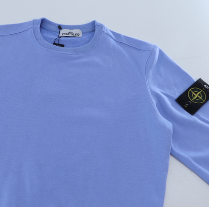 Light blue long-sleeve shirt with a brand tag on a light gray background