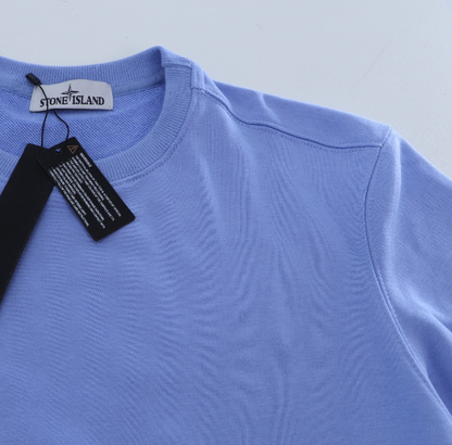 Light blue sweater with Stone Island tag on a light gray background