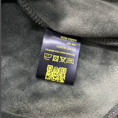 Clothing label with QR code on a gray fabric background