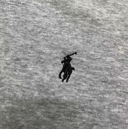 Close-up of a gray fabric with a black embroidered logo.